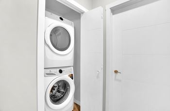 A white washing machine and dryer in a small laundry room.